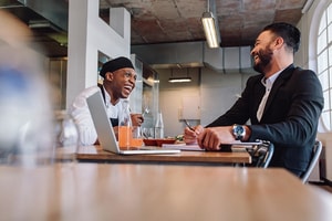 two people laughing at a table