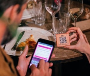 man using sunday app on smartphone to pay bill via QR code