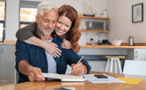 woman hugging man from behind while he goes over succession planning