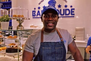 Orran Booher standing in front of the baker dude sign 