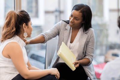 Woman comforting another woman, creating open dialogue within the team.