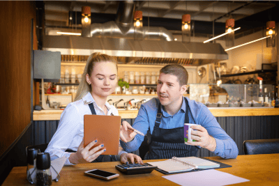 Woman and man in a restaurant going over paperwork
